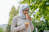 一位戴头巾的年轻女子在春天的户外享用牛角面包和饮料