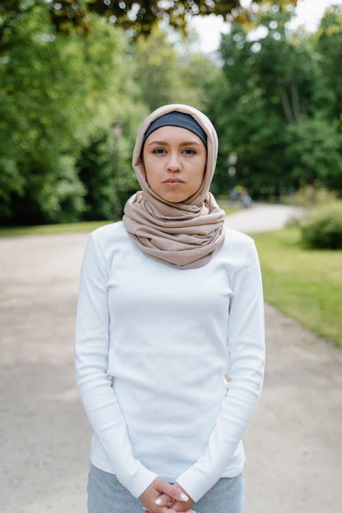Woman Standing in White Long Sleeve Shirt Wearing Beige Hijab