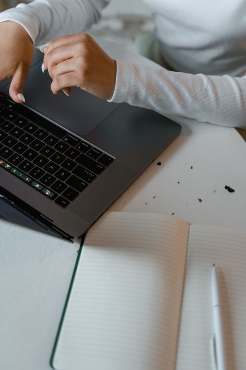 Content creator working on linkable asset at laptop with notebook
