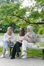 2 Women Sitting on White Bench