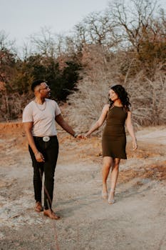 白天，浪漫的情侣在自然环境中手拉手散步