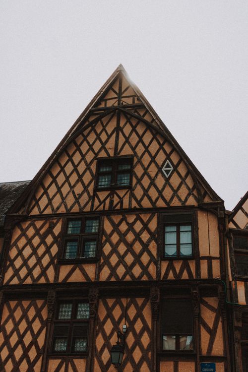 Free Low angle shot of a Gothic-style timber-framed building facade on a cloudy day. Stock Photo