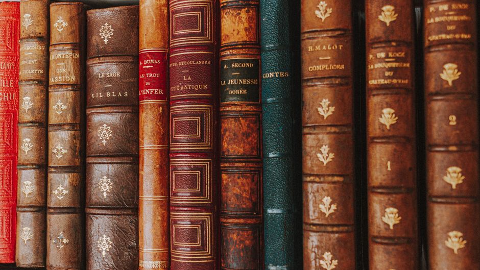 Close-up of vintage leather-bound books showcasing ornate spines.