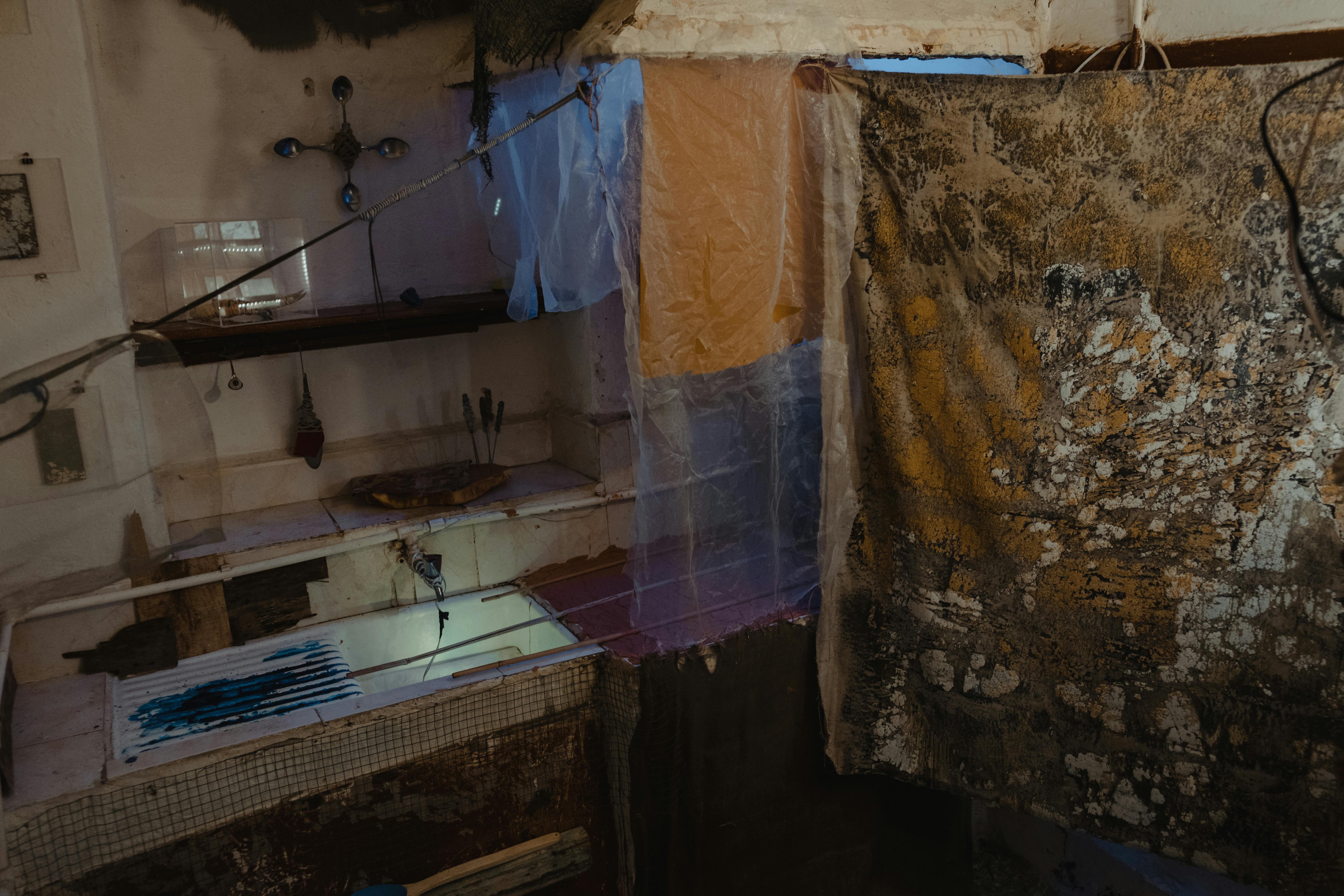 Terracotta Wall Paint In A Small, Cluttered Room With Dusty Textures And Red Earth Tones