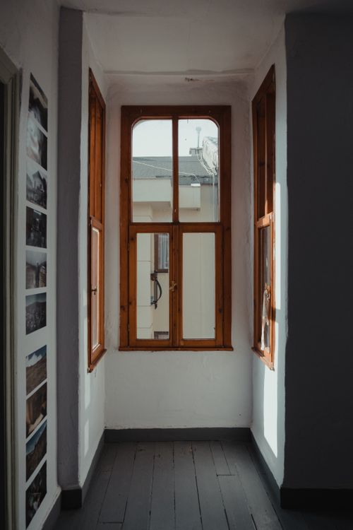 Free Bright indoor hallway with wooden-paneled windows filtering sunlight, creating a cozy atmosphere. Stock Photo