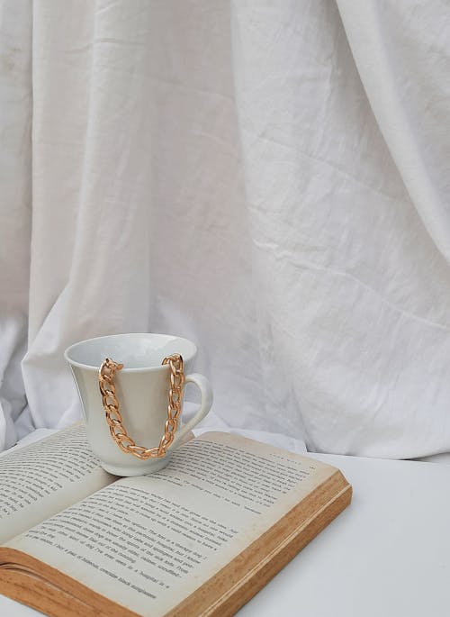 Photo of a Gold Chain Necklace in a White Ceramic Mug