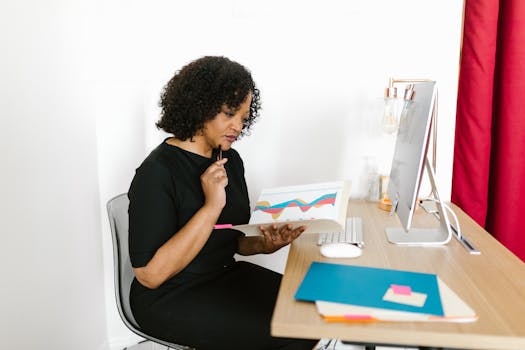 African American woman reviewing business charts in a modern office setting.