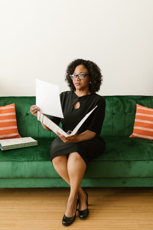 Woman Wearing Black Dress Sitting on Green Couch