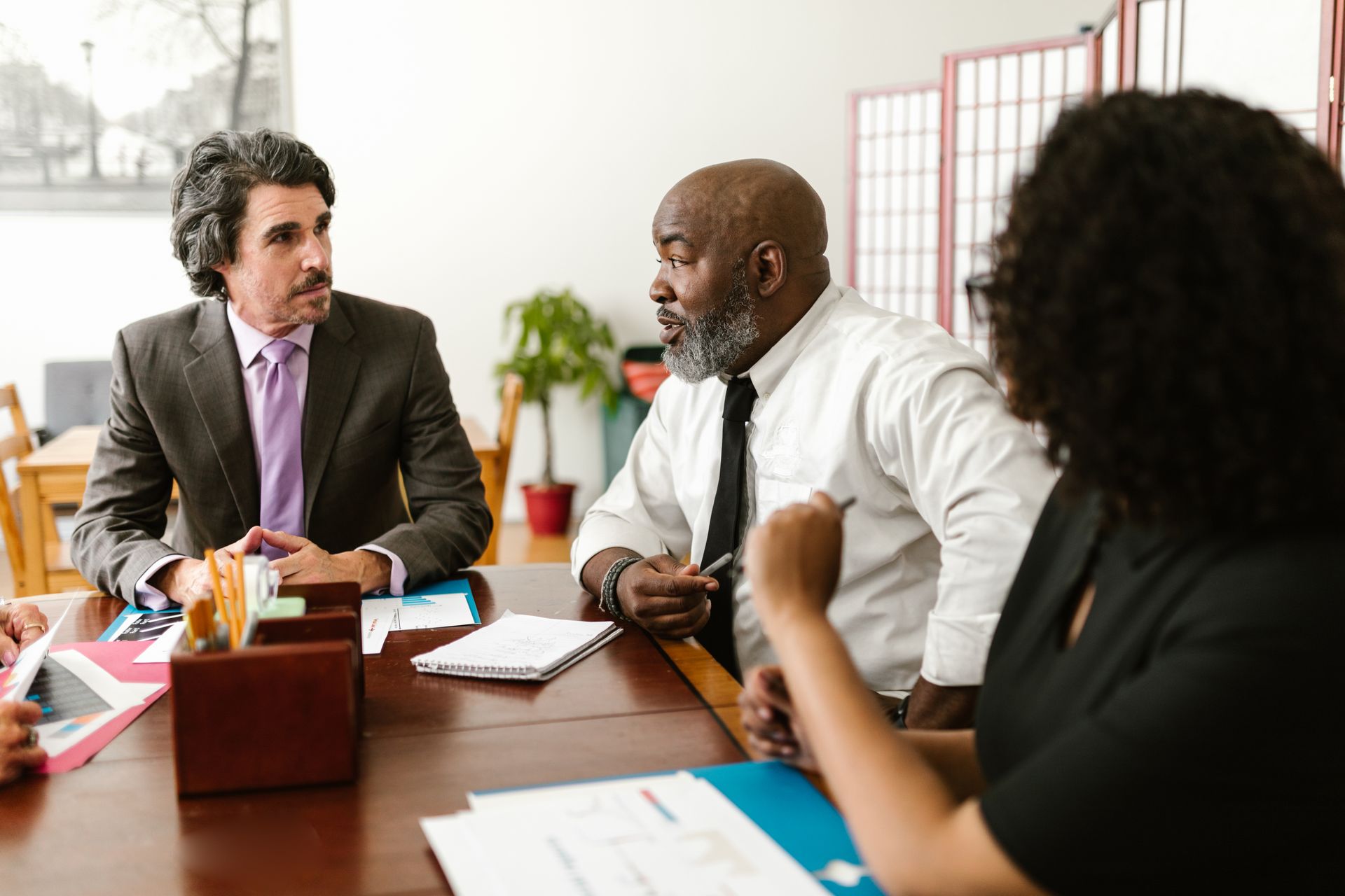 Diverse team of colleagues discussing at a workplace meeting.