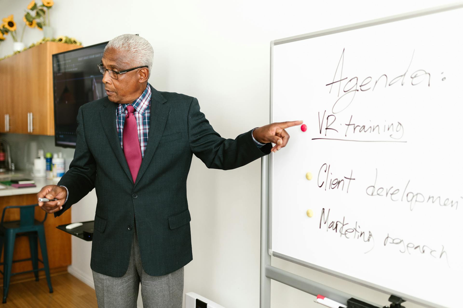 Senior African American businessman presenting VR training agenda during office meeting.