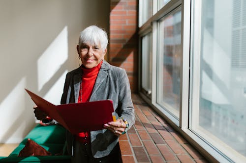 Smiling Gray Haired Woman Holding a Red Folder