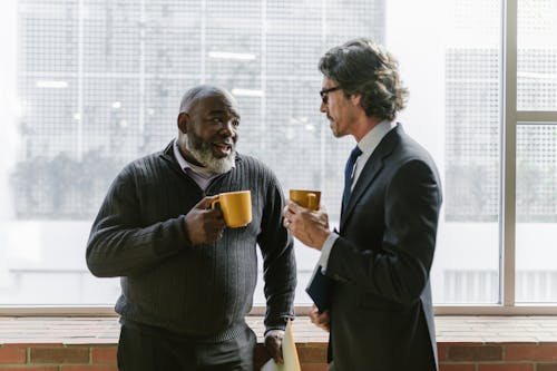 Free Businessmen Holding Coffee while Having Conversation Stock Photo