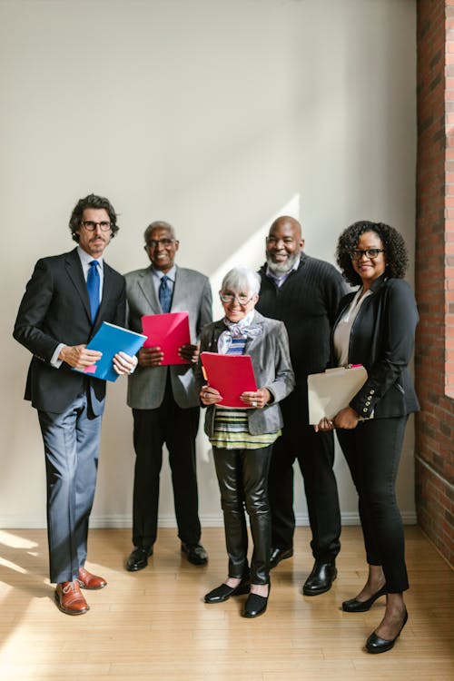 Group of People Happily Standing while Holding Folders