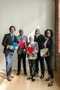 Group of People Happily Standing while Holding Folders