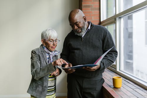 Free An Elderly Man and Woman Having Conversation while Looking at the Folder Stock Photo