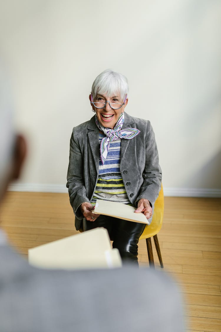 A Woman In Gray Blazer Sitting On A Chair