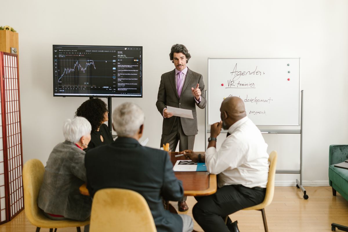 A professional presenting market data to colleagues during a corporate meeting