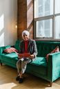 Woman in Black Jacket Sitting on Green Couch