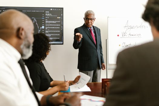Senior executive conducting a business meeting with colleagues, discussing agenda on a whiteboard.