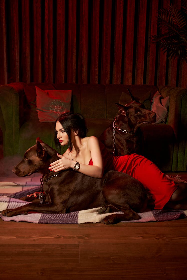 Female And Doberman Lying On Floor Near Couch