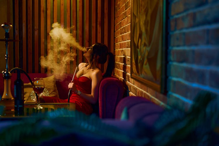 Stylish Female Smoking Hookah In Bar