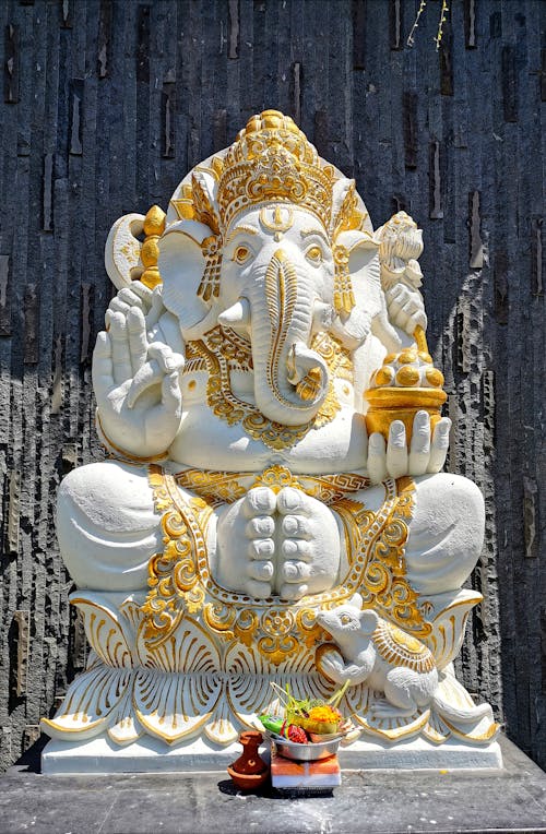 White and Golden Ganesh Statue Beside Black Wall