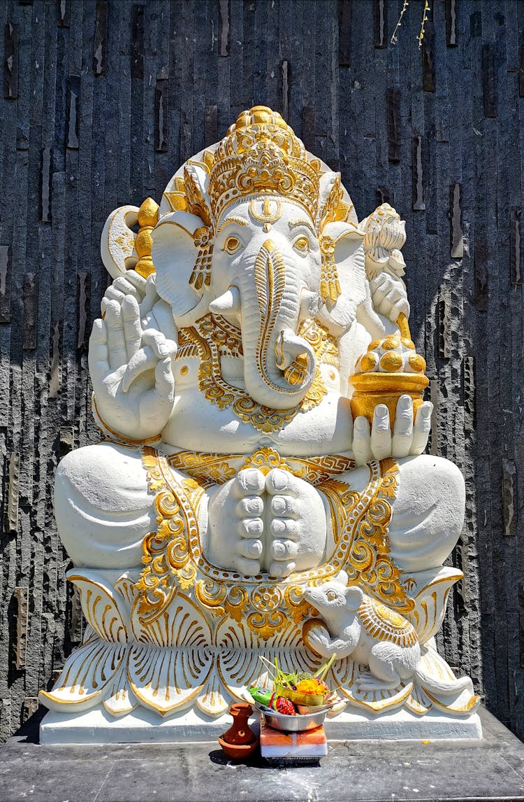 White And Golden Ganesh Statue Beside Black Wall