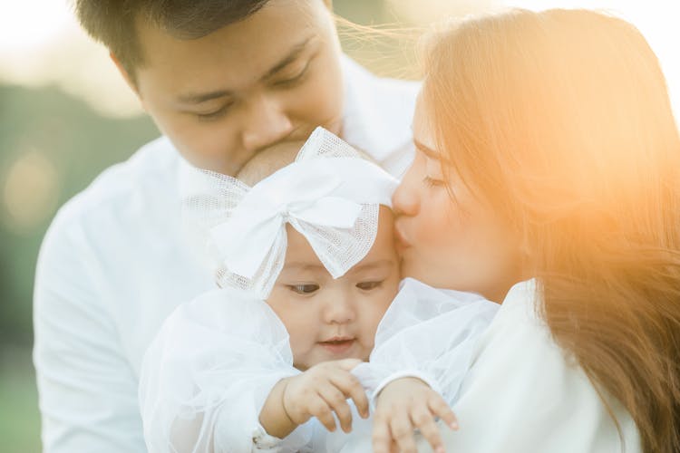 Couple Holding A Baby With Ribbon