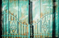 这扇绿松石金属大门设计质朴，饰有复杂图案，非常适合户外主题