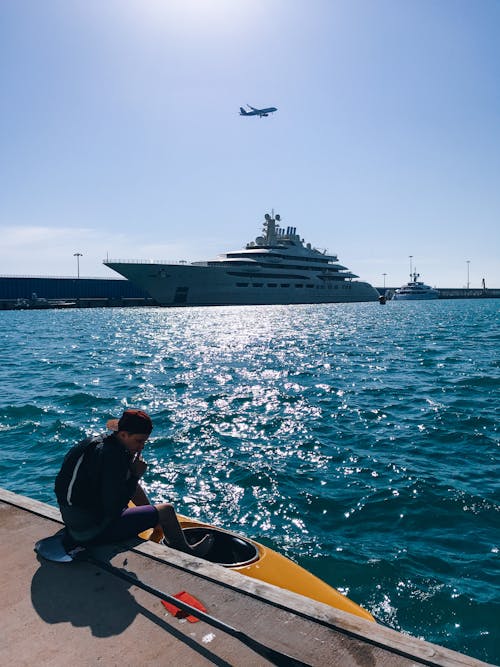 A Man Sitting Near the Body of Water