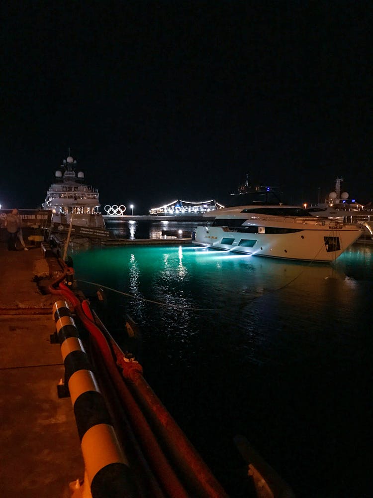 White Boat With Green Lights On Dock During Night Time