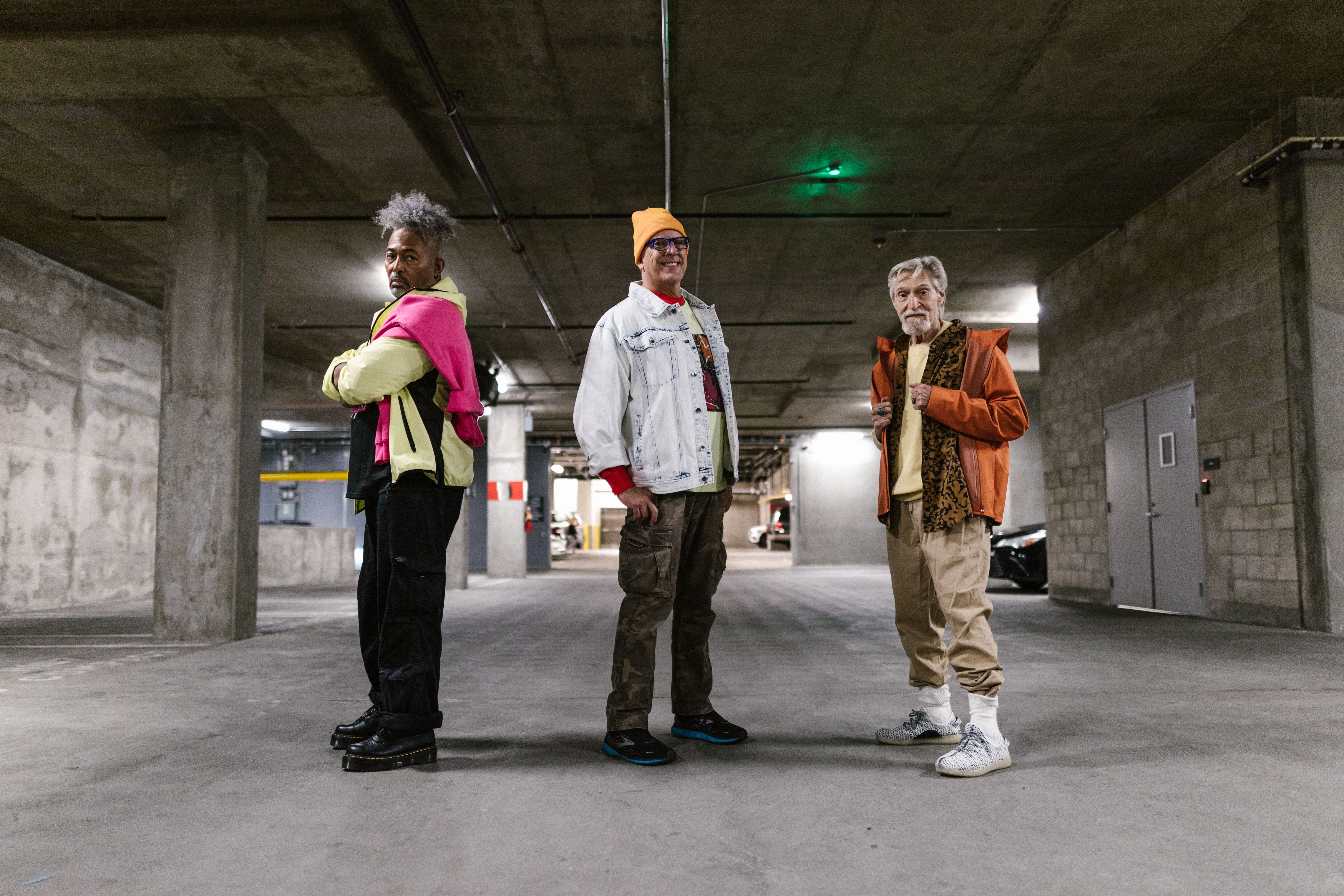 Elderly men showcasing fashionable street style outfits in an industrial setting.