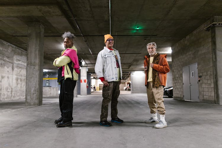 A Group Of Elderly Men Posing While Standing On A Concrete Floor