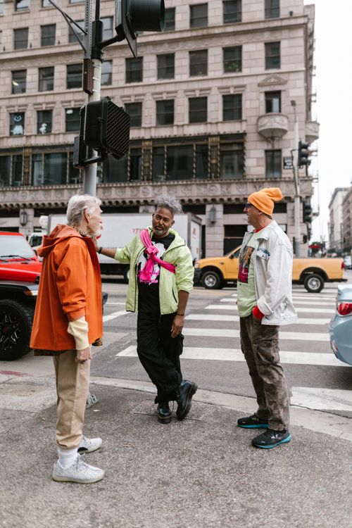 Free Stylish senior adults chat on a city street corner in fashionable outfits. Stock Photo