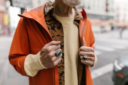 Elderly Hands Holding an Orange Jacket