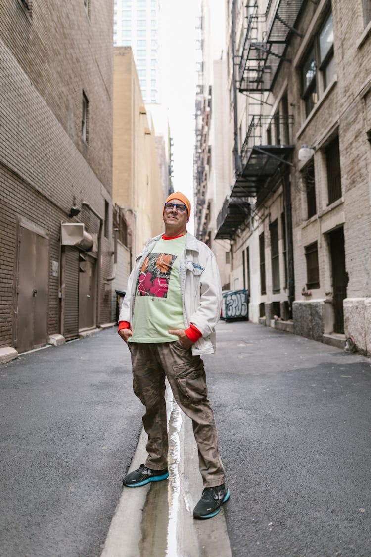 Tall Man Standing Between Buildings With Hands In The Pockets