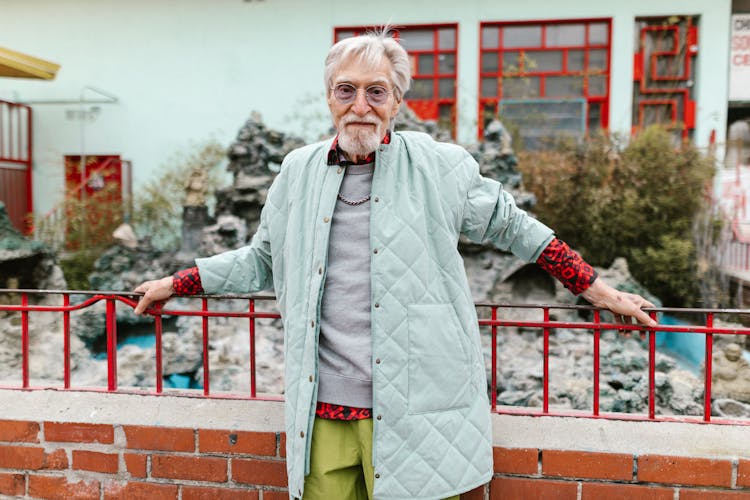 A Stylish Man Leaning On A Metal Railing