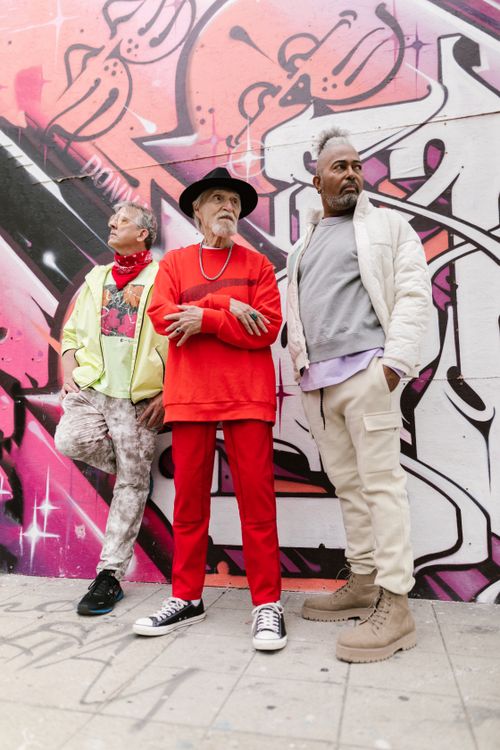 Free Three senior men in vibrant urban fashion against a colorful graffiti wall. Stock Photo
