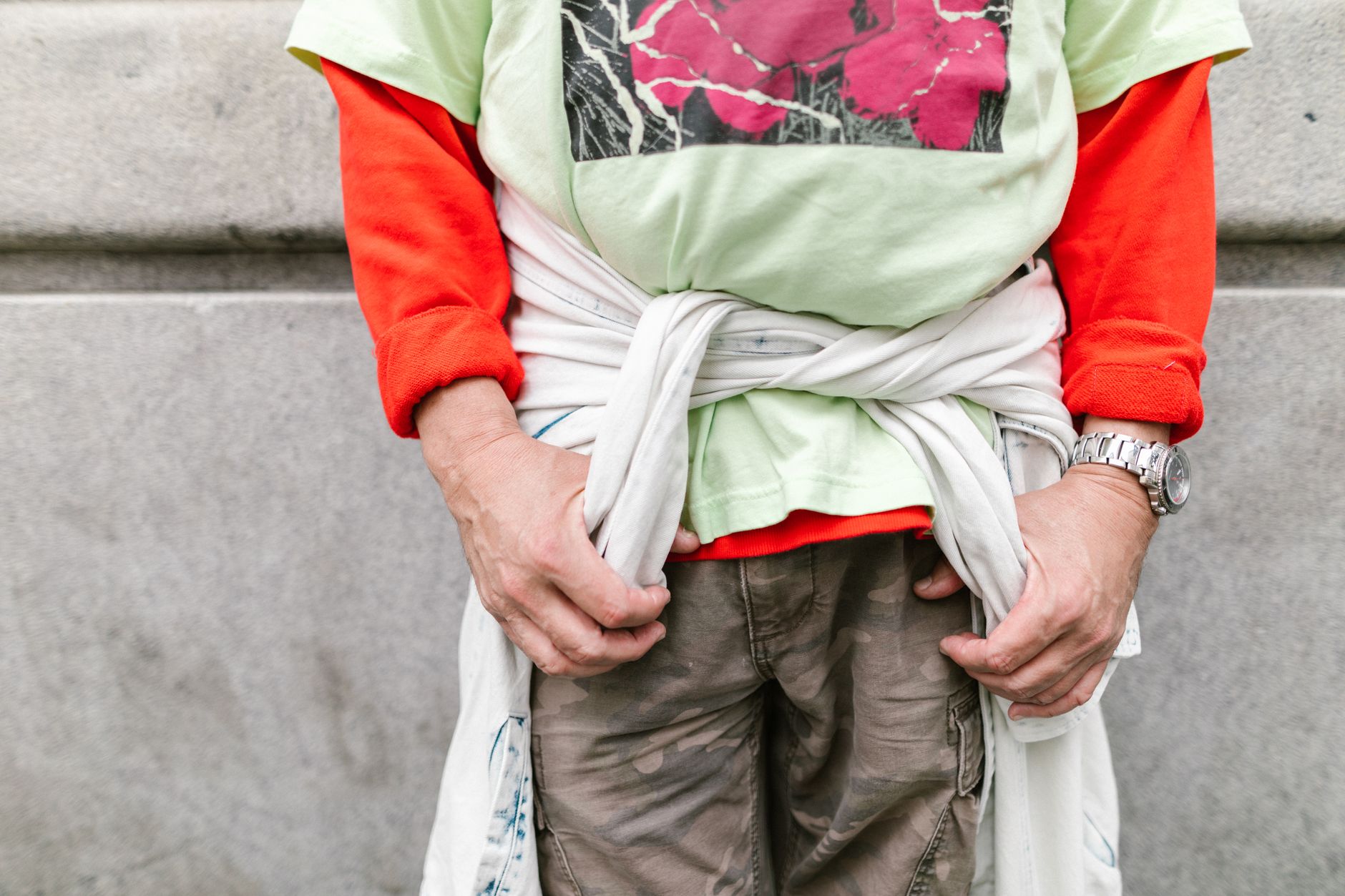 Homme en pull cachemire gris porté en look streetwear complet avec accessoires urbains