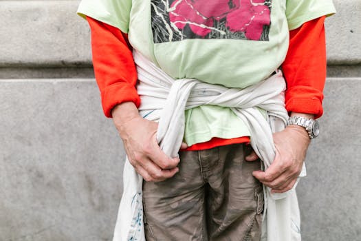 Close-up of a person wearing colorful layered clothing with a watch, showcasing casual fashion.