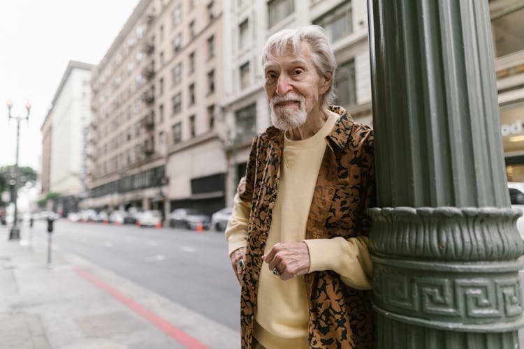 Elderly Man Leaning On The Pole Light