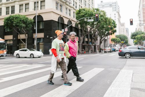 Free Two men cross a downtown intersection on a zebra crossing in an urban environment. Stock Photo