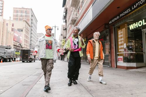 Free Fashion-forward friends walking downtown, showcasing colorful street style and joyful camaraderie. Stock Photo