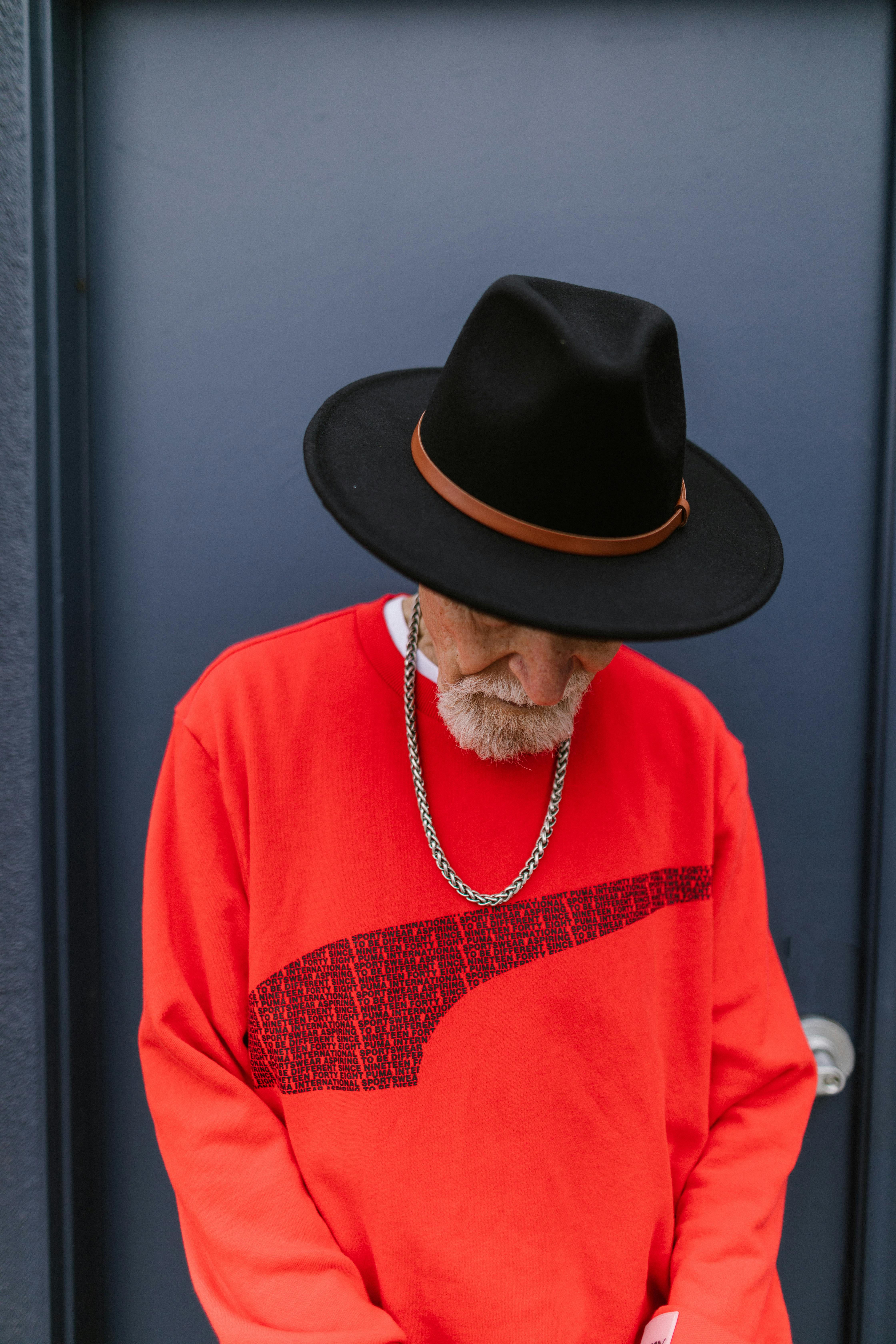 Stylish Elderly Man wearing Red Sweater and Black Fedora Hat