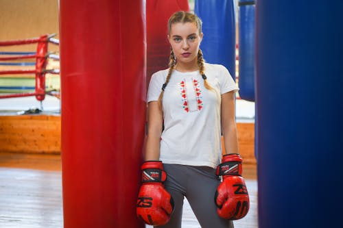 Free A Woman Standing Between Punching Bags Stock Photo