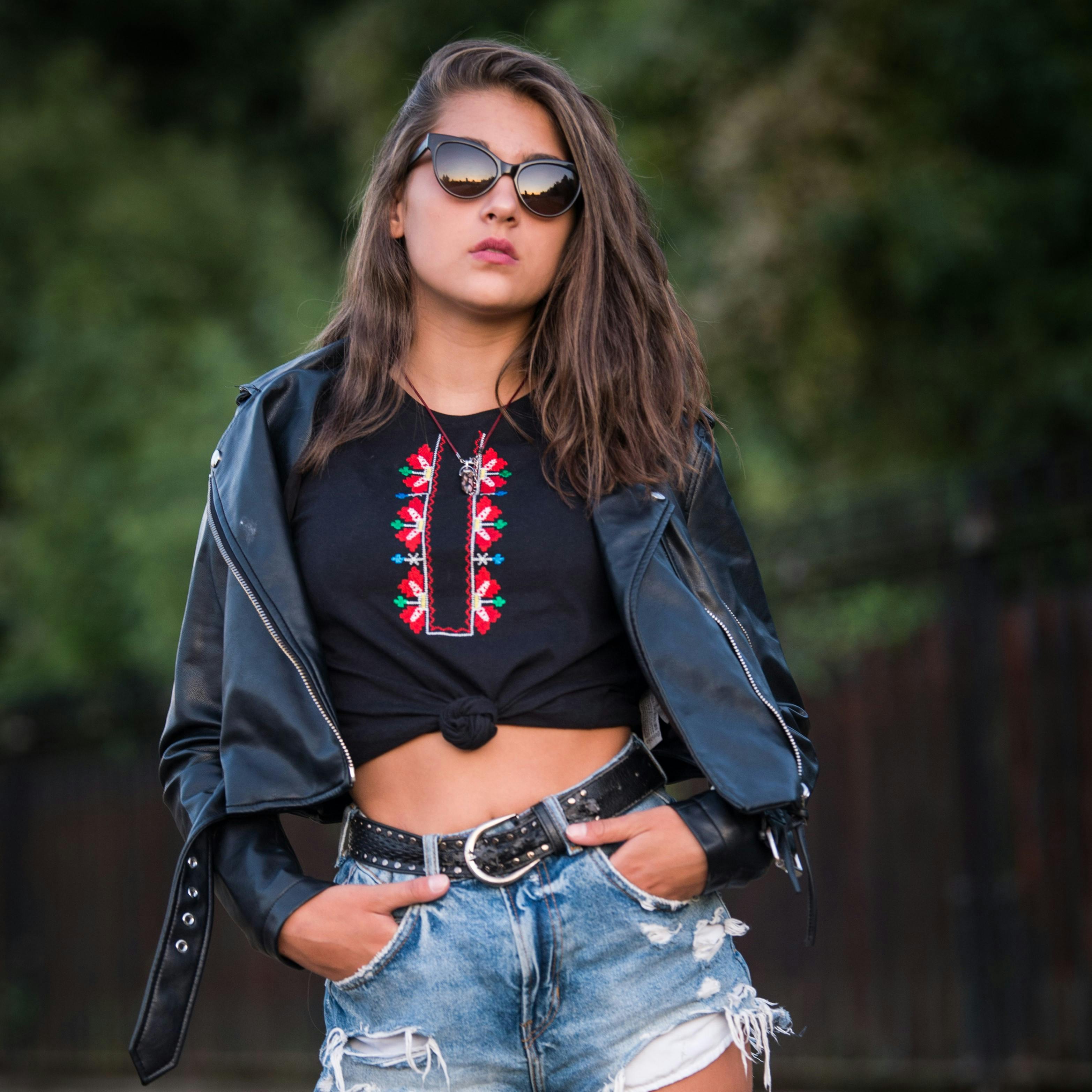 Brunette Woman in Leather Jacket and Denim Mini Shorts Posing by a  Motorcycle · Free Stock Photo