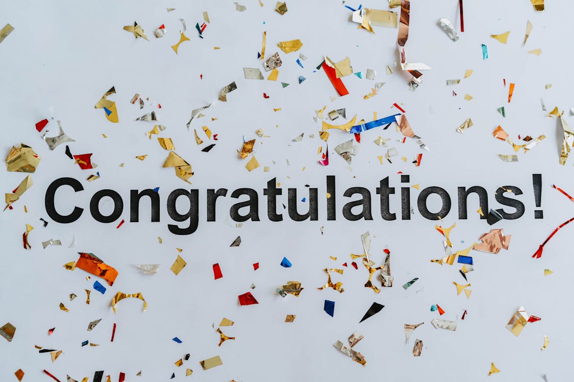 Free Congratulations Text on White Surface with Confetti  Stock Photo