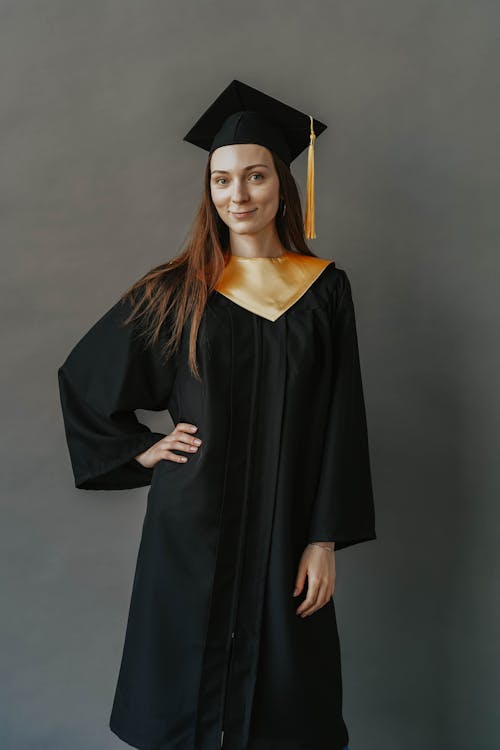 Foto gratuita di cappello di laurea, donna, laurea, laurearsi, tiro  verticale, toga