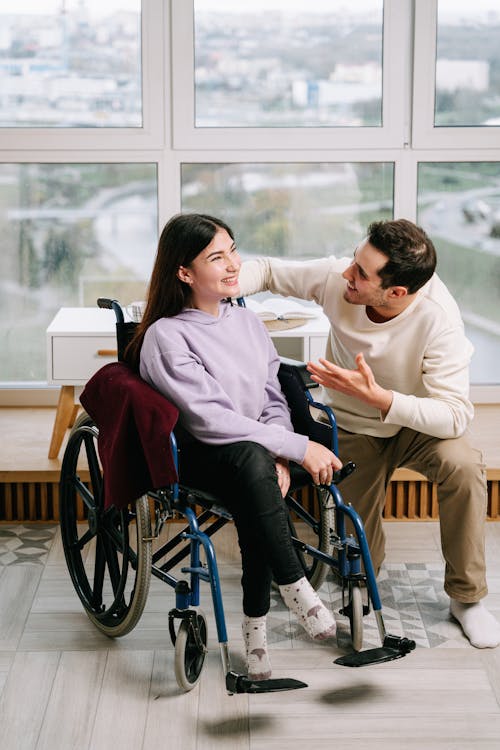 Free Man Smiling at the Woman in Wheelchair Stock Photo