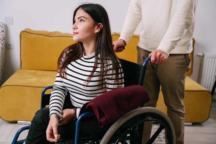 A wheelchair user being supported in a warm home setting